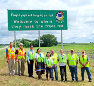 New Dakota-English Sign Welcomes Travelers to 'Where They Mark the Trees Red'